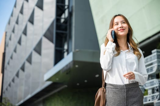 Beautiful young Asian woman calling and talks on telephone or mobile phone in city, Portrait of businesswoman smiling talking on mobile phone, people and technology communication concept