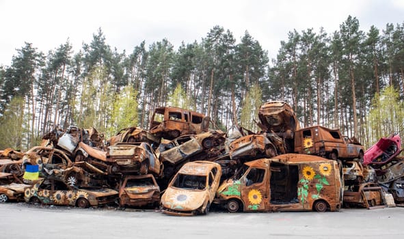 A lot of burnt fired cars in the parking lot, the consequences of the invasion of Ukraine. War in Ukraine. Cemetery of destroyed cars of civilians who tried to evacuate from the war zone