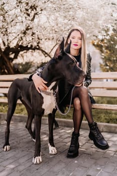 A woman walks with her Great Dane in an urban setting, enjoying the outdoors and the company of her dog