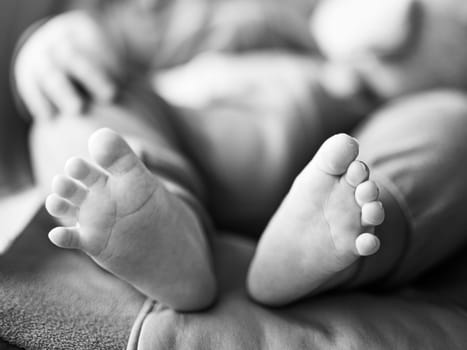 Close-up of cute little baby feet, innocence concept. Black and white image