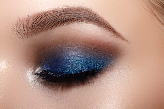 Closeup Macro of Woman Face with Blue Eyes Make-up. Fashion Celebrate Makeup, Glowy Clean Skin, perfect Shapes of Brows. Shiny Simmer and Rouge