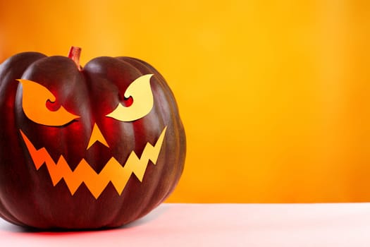 Halloween Pumpkin with Paper Cut Scary Face on Yellow Background. Jack Halloween. Smile Jack Pumpkin. Copy space