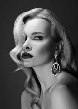 Beautiful Sexy Woman with Fashion Make-up and Blond Curly Wave Hairstyle, Bright Accessories. Glamour Pin-up Girl with Red lips. American Diva Style with Brilliant Earrings. Black and White Photography