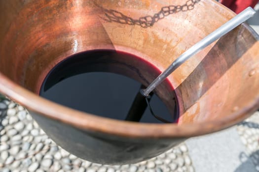 Vin brulé (mulled wine). Huge copper cauldron with the tasty mulled wine cooked over the fire. Typical of the mountainous areas of northern Italy and central Europe.