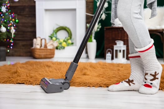 Thorough vacuuming of the floor before the celebration of an important Christian beheading. A decorated living room for Christmas.
