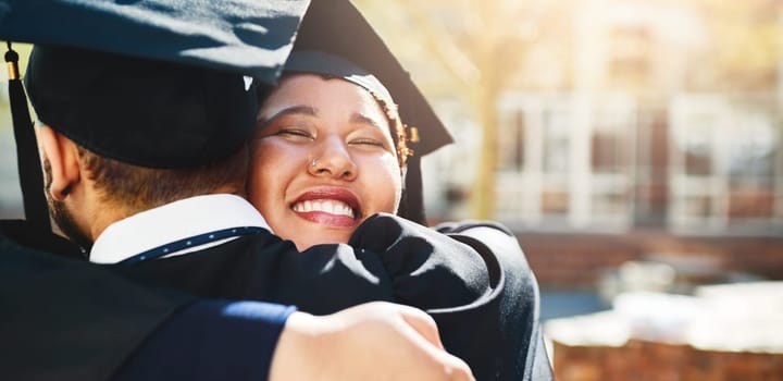 Cropped shot of a young woman embracing her male friend after graduating.