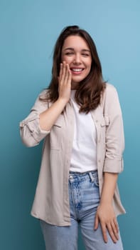 cheerful positive brunette 30 year old female person dressed in a shirt and jeans laughs and makes a face.