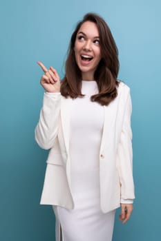 charismatic brunette young woman in white dress flirting on studio background.