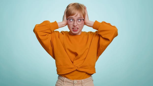 Dont want to hear and listen. Frustrated annoyed irritated woman covering ears gesturing No, avoiding advice ignoring unpleasant noise loud voices. Pretty blonde girl isolated alone on blue background