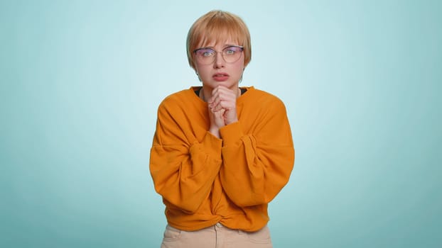 Stressed depressed young woman terrified about danger problems, suffering phobia, anxiety disorder, expresses fear, waving no, insecure, stress, panic. Blonde girl isolated on blue studio background
