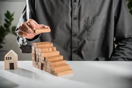Business hand arranging put wooden block stacking step stair growth success process, financial risk management and strategic plan and business challenge planning concept, prevent collapse or crash