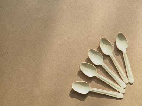 Ecology, zero waste. Wooden, biodegradable fiver forks. Concept of environment preservation and protection. Eco friendly disposable kitchenware utensils on craft paper background. Top view. Copy space