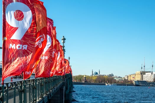 St. Petersburg, Russia - May 08, 2023. Festive flags for the Victory Day decorate the Trinity Bridge. Selective focus. Place for text. On the flags there is an inscription - May 9, Victory.