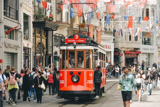 Istanbul, Turkey - May 02, 2023: Nostalgic traditional red tram in Beyoglu. The tram line runs along Istiklal Street (a popular place in Istanbul) between Taksim Square and the metro.