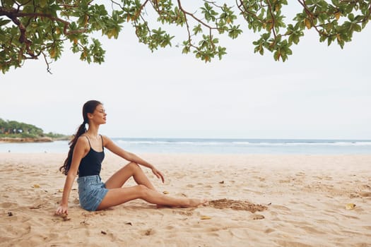 woman alone pretty person female sitting attractive sand beach tropical tan hair holiday vacation smile bali freedom relax nature travel sea