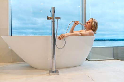 woman in freestanding white bath. Modern bathroom interior design. Beauty, healthy lifestyle concept. panoramic bathroom interior