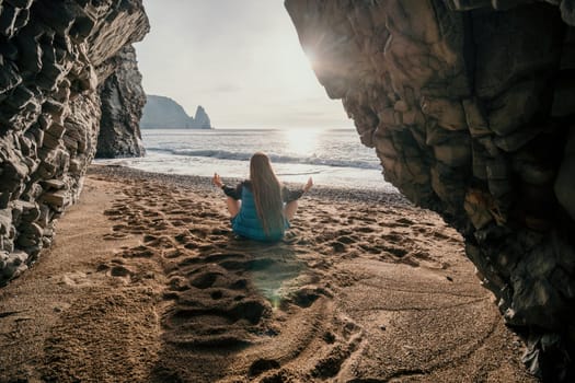 Middle aged well looking woman with black hair doing Pilates with the ring on the yoga mat near the sea on the pebble beach. Female fitness yoga concept. Healthy lifestyle, harmony and meditation.