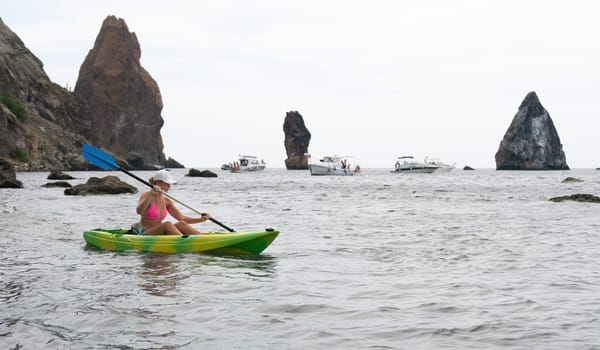 Kayaking. Travel adventure kayak on the tropical sea on a sunny day. Woman rowing a canoe.