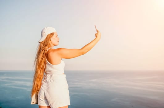 Woman travel sea. Young Happy woman in a long red dress posing on a beach near the sea on background of volcanic rocks, like in Iceland, sharing travel adventure journey