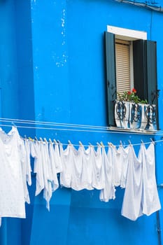 The characteristic colored houses of Burano (Venice) reflected on the water of a canal