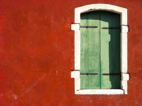 green window on red wall with white and black details