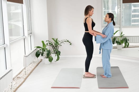 Caucasian woman stands on sadhu boards with therapist support