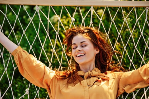 a close horizontal photo of a beautiful woman lying in a hammock with her eyes closed enjoying a rest. High quality photo