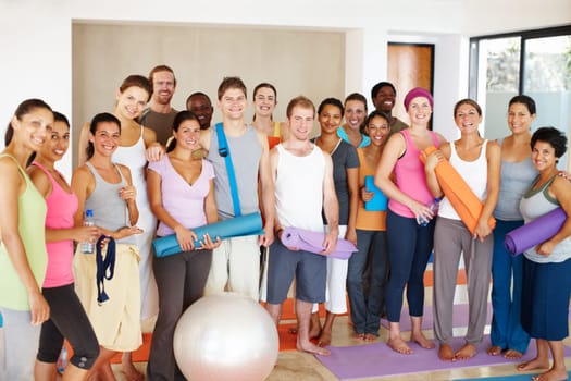 Happy in their yoga class. Portrait of a a group of yoga enthusiasts standing in a yoga studio