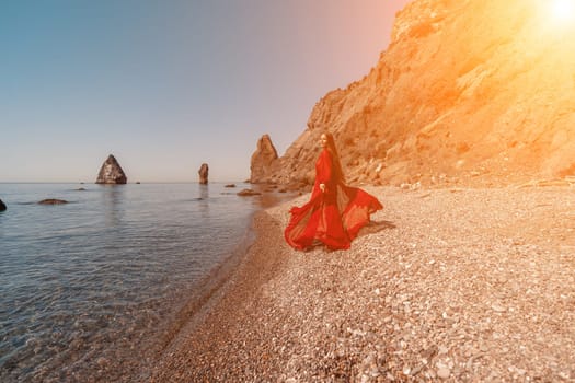 woman sea red dress Happy woman in a flying red dress and with long hair, stands on the seashore.