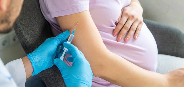 A pregnant woman makes a vaccination. Selective focus. doctor.