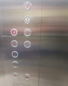 Close-up of the numbers on the buttons in a modern metal elevator, vertical.