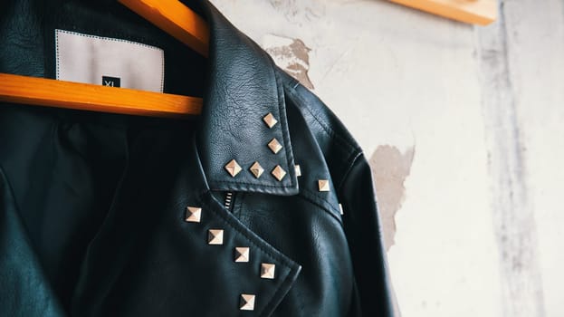 Close-up of leather jacket hanging on wooden hanger