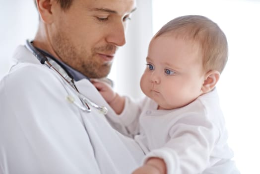 Doctor, pediatrician and holding baby for healthcare assessment, medical support and growth. Newborn kids, man and pediatrics service in clinic, hospital or expert consulting for wellness of children.