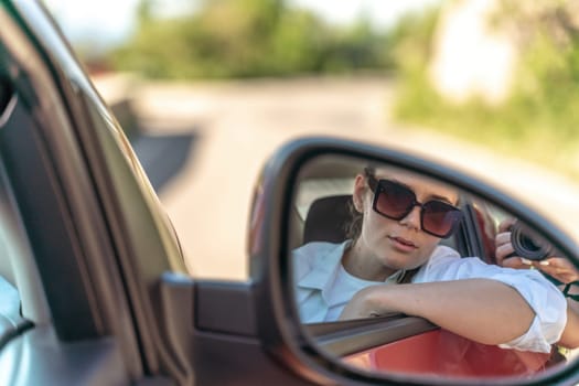 Woman car mirror. Portrait of a beautiful woman in a new car looking in the rearview mirror.