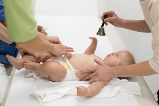 Baby beeing vaccinated by pediatrician in presence of his mother. Preventive vaccination against Diphtheria, whooping cough, tetanus, hepatitis, haemophilus influenzae, pneumococcus, poliomyelitis.