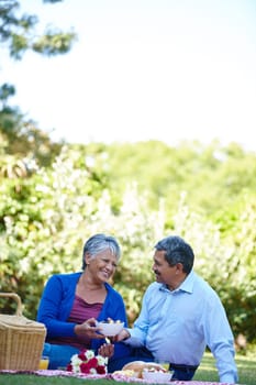 Fruit salad, my love. a loving senior couple enjoying a picnic together outdoors