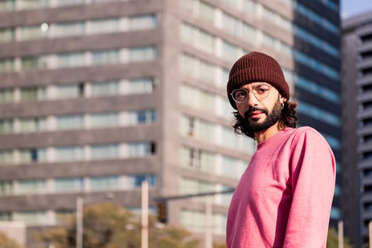 stylish young guy enjoying city morning looking at camera, concept of street style and urban lifestyle, copy space for text