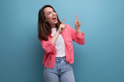 happy lucky brunette woman in informal look rejoices on studio background.