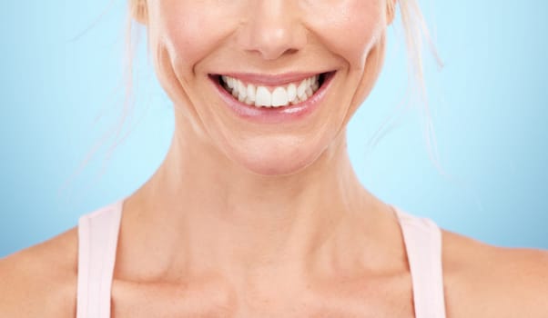 Smile, teeth whitening and woman mouth in studio, blue background and facial wellness. Closeup female model, clean dental and happy face of fresh breath, tooth implant and healthy aesthetic beauty.