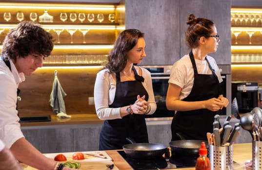 Two professional chefs preparing food in large kitchen