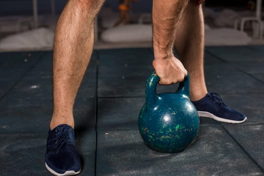 Muscular man working with weights at outdoor. sport exercises with kettlebell. street workout. close-up