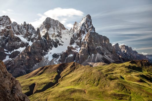 Cimon della Pala (also called "The Matterhorn of the Dolomites") with snow covered peaks grassy fields in foreground. San Martino di Castrozza, Italy.
