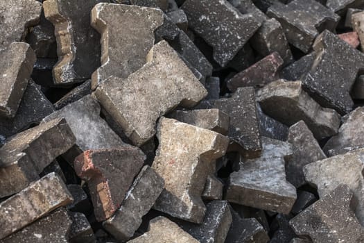 Pile of old discarded pavement (segmental paver) cobble stones.