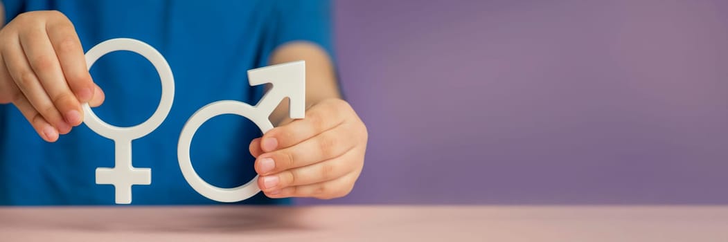 Gender equality banner. Symbols of the genders of a man and a woman in the hands on a purple background. Equal rights for men and women. Copy space