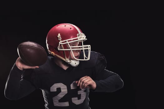 Soccer player on a dark background in vintage style. The classic American game. college Students. He makes the ball roll