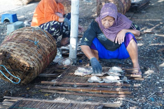 May 13, 2023. The preparation to dry the salted fish on a bamboo tray in Gresik, Indonesia. Street videography.