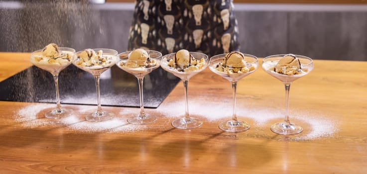 Tasty ice cream dessert made from chocolate and strawberry flavors with nuts and waffle cracker in glass bowl