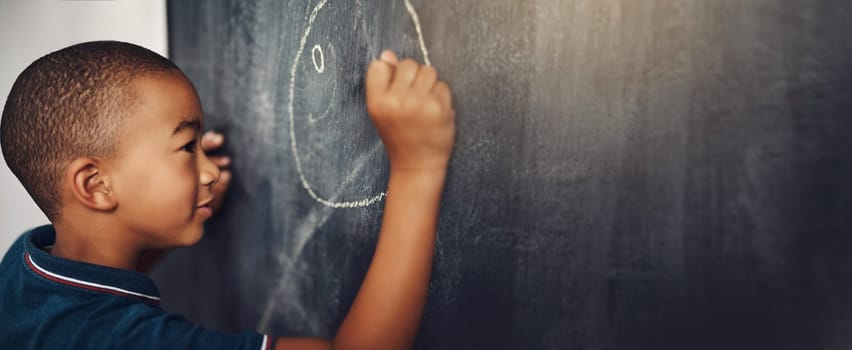 School, chalk and boy drawing on a board for child development, creativity and art for learning. Academic, creative and young kid student writing on a blackboard in the classroom with mockup space