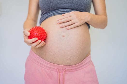 Self-massage with a massager for a pregnant woman.