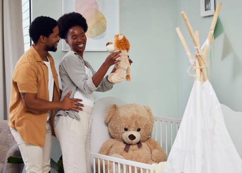 Love, pregnancy and couple with teddy bear in the nursery with excitement while preparing for their baby. Happy, smile and young African man with his pregnant wife looking at toy together in bedroom